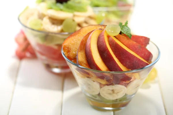 Beyaz tahta masada cam lezzetli meyve salatası kaseler — Stok fotoğraf