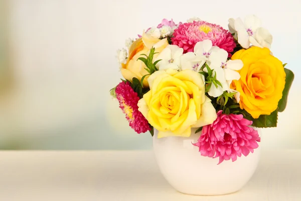 Güzel parlak zemin üzerine ahşap masa üzerinde renkli vazo içinde parlak çiçek buketi — Stok fotoğraf