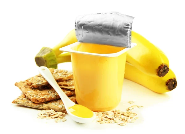 Sabroso yogur en copa de plástico abierta, galletas y fruta, aislado en blanco — Foto de Stock