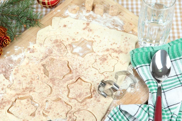 Fazer biscoitos de Natal na placa de madeira no fundo da toalha de mesa — Fotografia de Stock