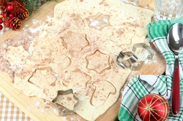 Dokonywanie ciasteczka świąteczne na desce na tle Obrus — Zdjęcie stockowe