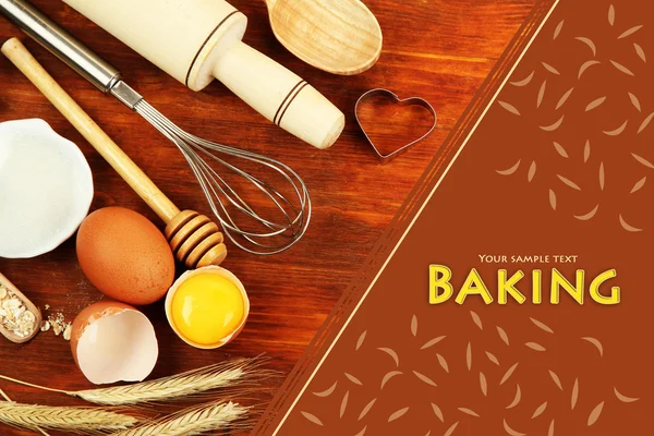 Cooking concept. Basic baking ingredients and kitchen tools on wooden table — Stock Photo, Image