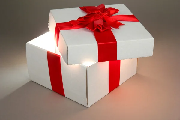 礼品盒与明亮的光，它在灰色的背景上 — 图库照片