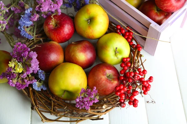 Saftige Äpfel in Schachtel auf weißem Holztisch — Stockfoto