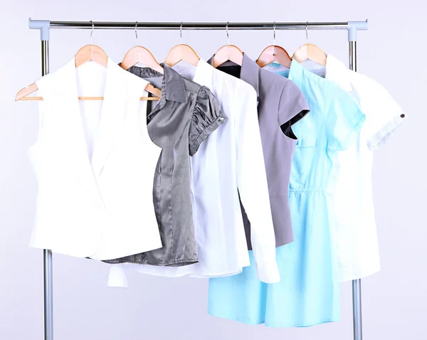 Офисная женская одежда на вешалках, на сером фоне — стоковое фото