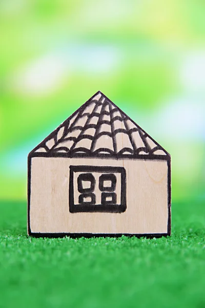 Casa in legno su erba su sfondo naturale — Foto Stock