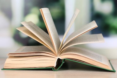 parlak zemin üzerine ahşap masa kitap açıldı