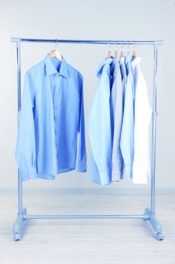 Askı, gri arka plan üzerinde Office erkek giyimi