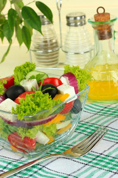 Griechischer Salat auf Teller auf Tisch auf hellem Hintergrund — Stockfoto