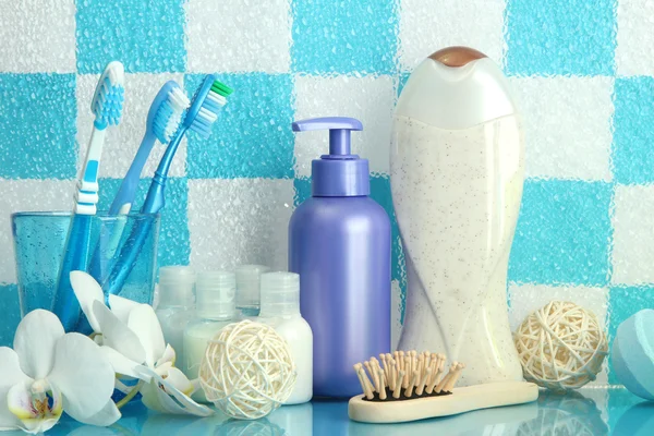 Accesorios de baño en el estante en el baño sobre fondo de pared de azulejo azul —  Fotos de Stock