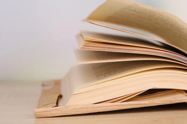 Opened book on wooden table on bright background — Stock Photo, Image