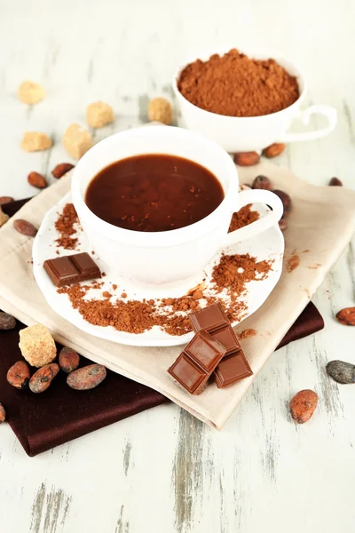 Poudre de cacao dans une tasse sur une serviette sur une table en bois — Photo