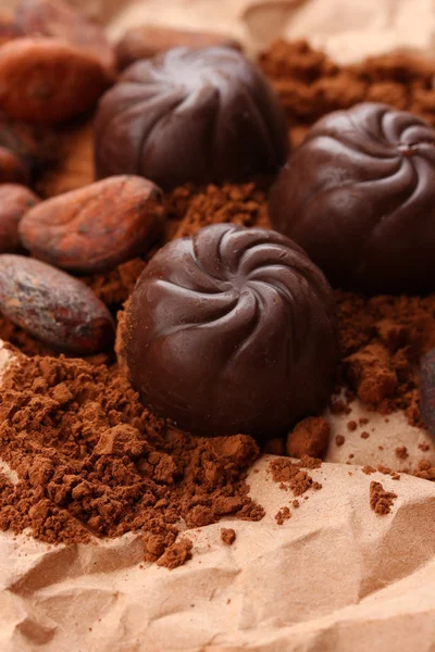 Склад шоколадних цукерок і какао на коричневому фоні — стокове фото