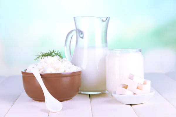 Frische Milchprodukte auf Holztisch vor natürlichem Hintergrund — Stockfoto