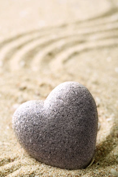Šedá zen kámen ve tvaru srdce, na písku pozadí — Stock fotografie