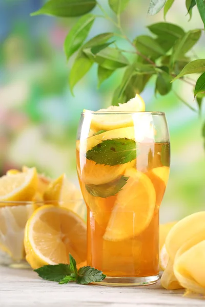 Ledový čaj s citronem a mátou na dřevěný stůl, venku — Stock fotografie