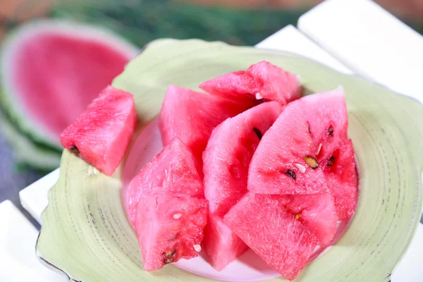 Watermelon slices on plate on table on grass background — Stock Photo, Image