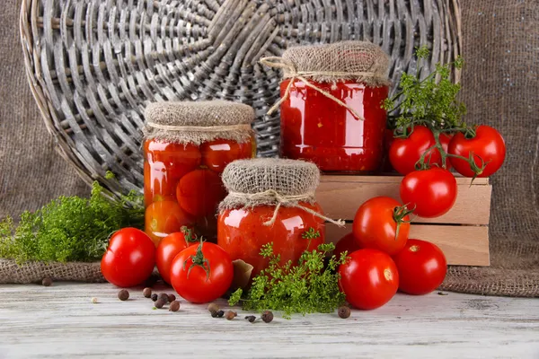 Ahşap masa üstünde lezzetli konserve ve taze domates — Stok fotoğraf