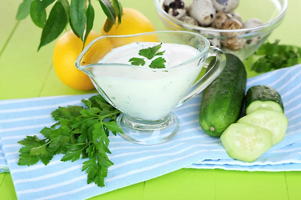 Yogur de pepino en un tazón de vidrio, en una servilleta de color, en un fondo de madera de color — Foto de Stock