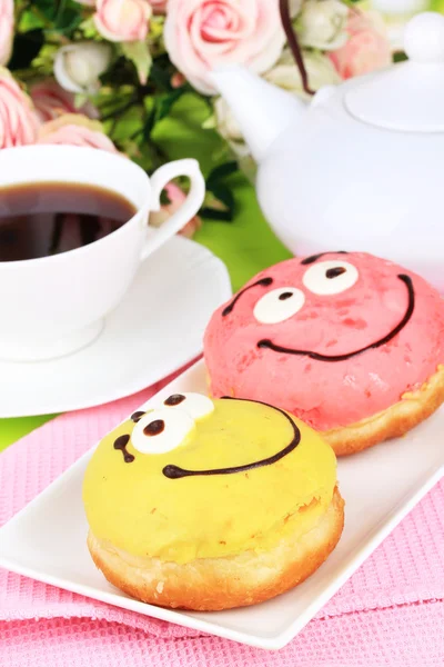 Doce donuts com xícara de chá na mesa close-up — Fotografia de Stock