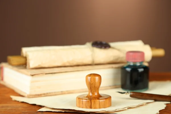 Wooden stamp, books and old papers on wooden table — Stock Photo, Image