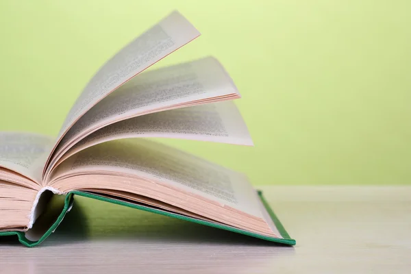 Opende boek op houten tafel op kleur achtergrond — Stockfoto