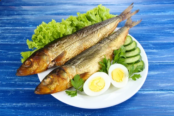 Pescado ahumado en plato sobre mesa de madera — Foto de Stock