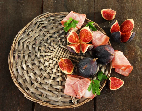 Figues savoureuses avec jambon sur table en bois gris — Photo