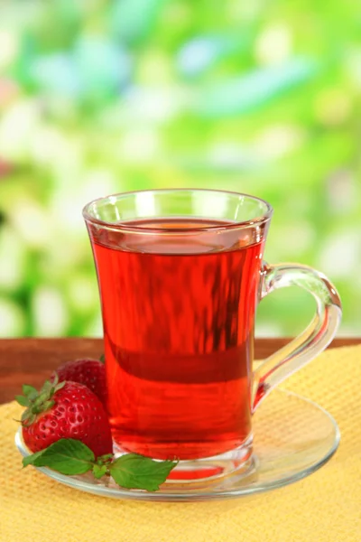 Delizioso tè alla fragola sul tavolo su sfondo luminoso — Foto Stock