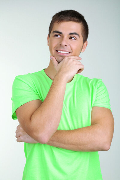 Портрет молодого человека на сером фоне
