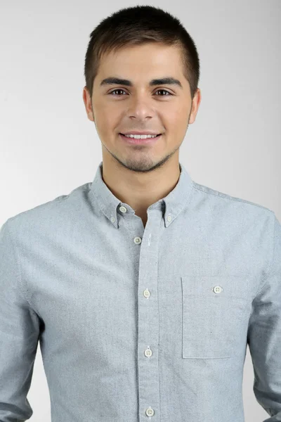 Portrait of young man on grey background — Stock Photo, Image