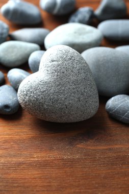 ahşap zemin üzerinde kalp şeklinde gri taş