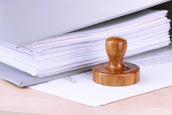 Wooden stamp and papers on table — Stock Photo, Image