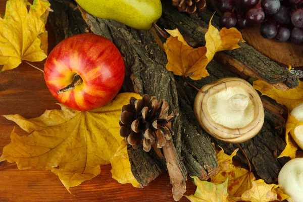 Vruchten met champignons en gele bladeren op houten achtergrond — Stockfoto