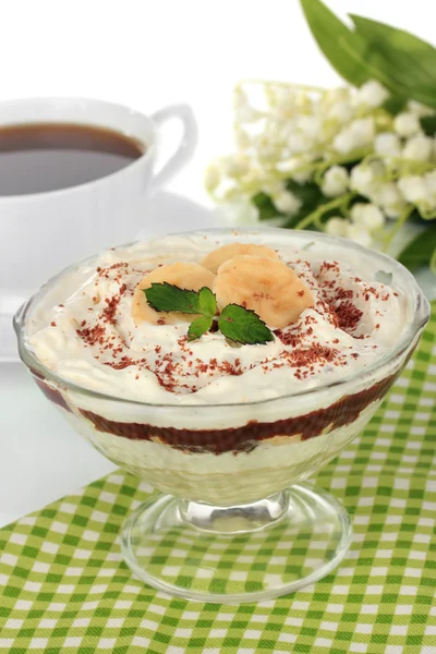 Deliciosa sobremesa com banana e caramelo na mesa sobre fundo branco — Fotografia de Stock