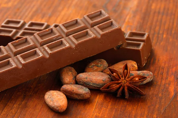 Läckra choklad barer med kakaobönor närbild — Stockfoto