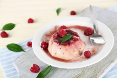 Panna cotta ahşap zemin üzerinde frambuaz sos ile