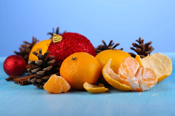 Рождественская композиция с мандаринами на деревянном столе на синем фоне — стоковое фото