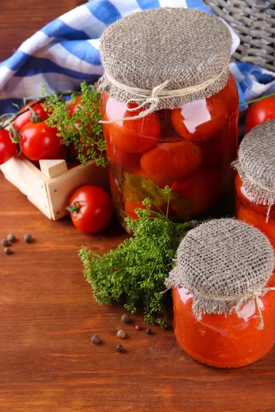 Tomates enlatados e frescos saborosos na mesa de madeira — Fotografia de Stock