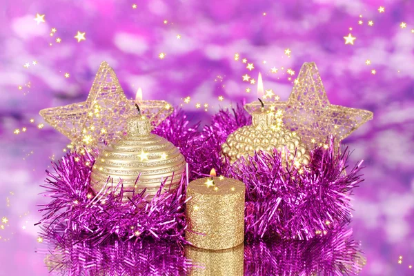 Christmas composition with candles and decorations in purple and gold colors on bright background