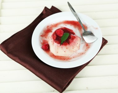 Panna cotta ahşap zemin üzerinde frambuaz sos ile