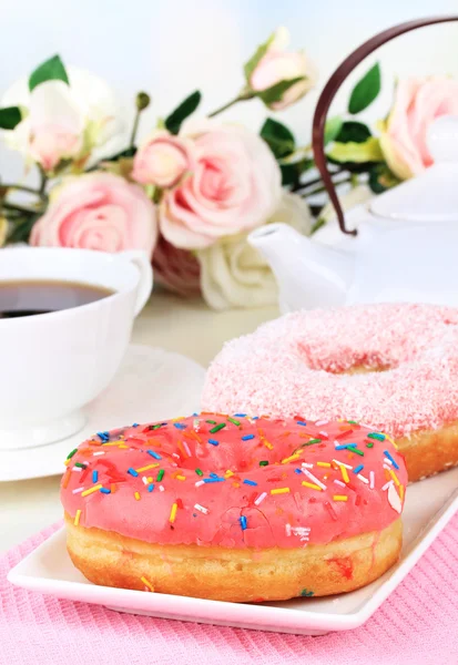 Sweet donuts with cup of tea on table close-up — Stock Photo, Image