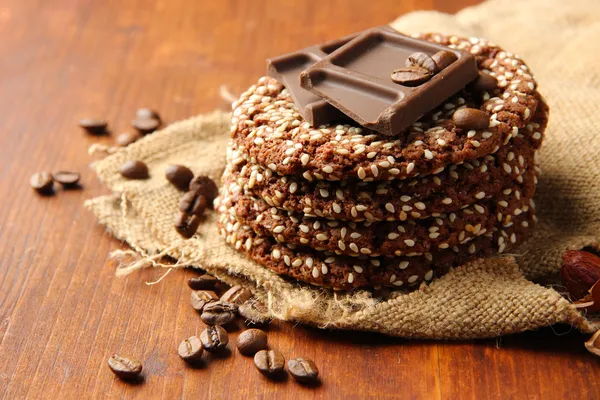 Zelfgemaakte koekjes met sesamzaad, chocolade, op houten tafel, op rouwgewaad achtergrond — Stockfoto