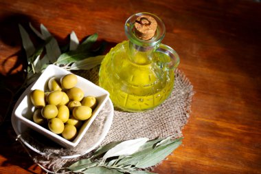 zeytinyağı ve zeytin ahşap masa üstünde çul üzerinde kase