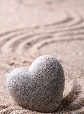 Gri zen stone kum arka plan üzerinde kalp şeklinde
