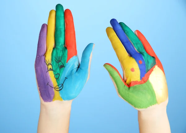 Painted hands with smile on blue background — Stock Photo, Image