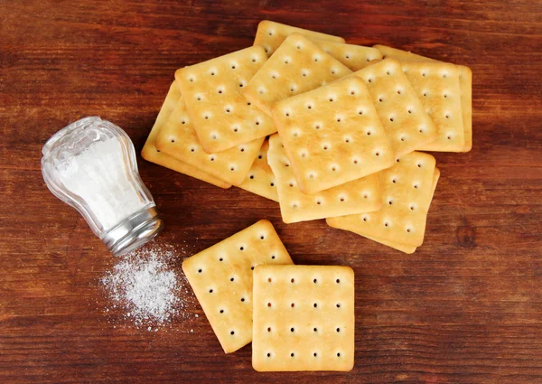 Deliziosi cracker con sale su sfondo di legno — Foto Stock