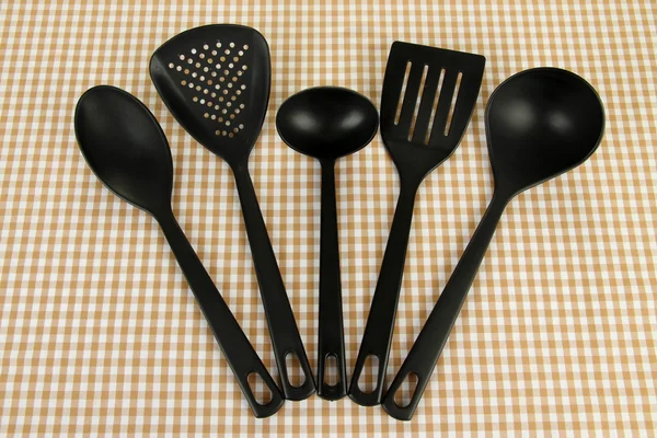 Plastic kitchen utensils on fabric background — Stock Photo, Image