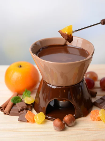 Fondue de chocolate com frutas, na mesa de madeira, no fundo claro — Fotografia de Stock