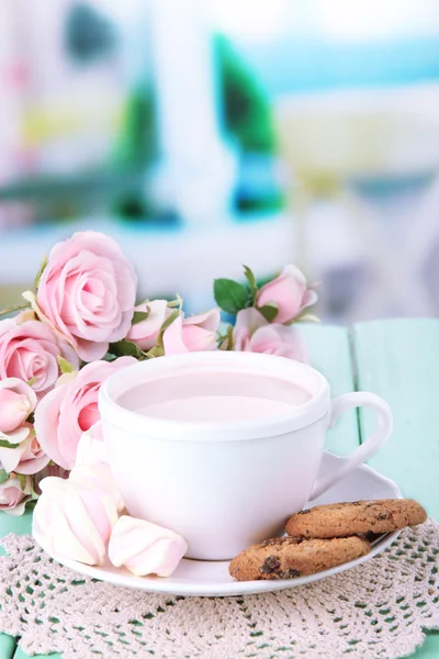 Cocoa drink on wooden table, on bright background